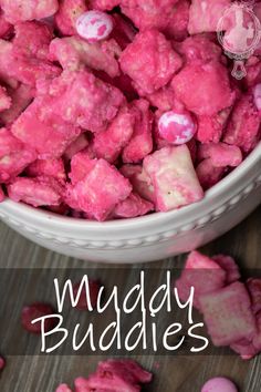 pink muddy buddies in a white bowl on top of a wooden table with text overlay