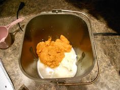 a metal container filled with food on top of a counter next to utensils