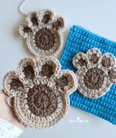 two crocheted monkey head ornaments on top of a blue cloth