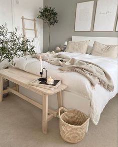 a white bed sitting next to a wooden table with a candle on top of it