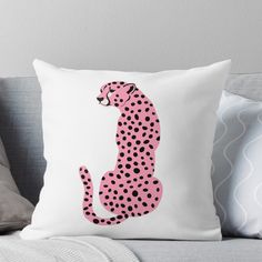 a pink and black cheetah throw pillow sitting on top of a gray couch