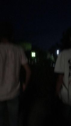 two people walking in the dark at night