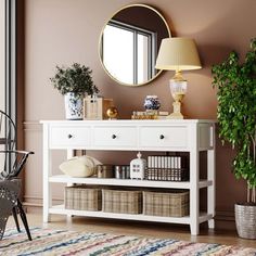 a white console table with baskets under it and a mirror on the wall behind it