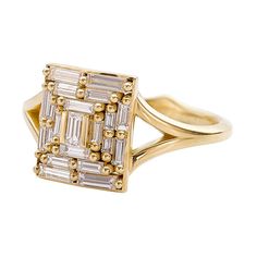 an 18k gold ring with baguettes and diamonds on the sides, set against a white background