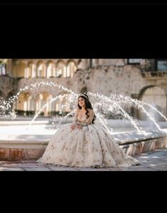 a woman in a wedding dress sitting on a fountain