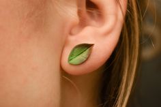 a close up of a person's ear with a leaf on it