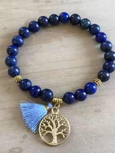 This beautiful bracelet is made of 8mm lapis lazuli beads, gold spacers and it is adorned with a tree of life pendant and a mini tassel 20mm. The bracelet shown fits to 7.75 inches wrist but you can choose your own wrist size. Lapis Lazuli *third eye and throat chakra *stimulates wisdom and good judgement *activates the higher mind and enhances intellectual ability *enhances the desire for knowledge, truth and understanding *is a stone of truth that deepens communication with calmness and loving Adjustable Lapis Lazuli Beaded Bracelets Bohemian Style, Blue Bohemian Bracelets For Meditation, Bohemian Blue Bracelets For Meditation, Bohemian Lapis Lazuli Beaded Bracelets, Bohemian Beaded Bracelets With Lapis Lazuli Stones, Bohemian Lapis Lazuli Beaded Bracelets With Natural Stones, Bohemian Beaded Bracelets With Lapis Lazuli, Bohemian Lapis Lazuli Beaded Bracelets As Gift, Bohemian Lapis Lazuli Bracelet As A Gift