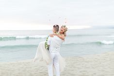 a bride and groom on the beach throwing confetti in the air at sunset