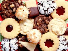 a plate full of cookies and pastries sitting on a tablecloth with red and green designs