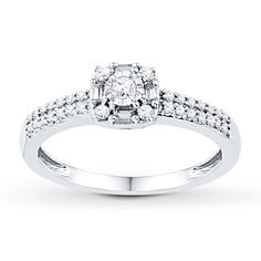 a white gold ring with diamonds on the sides and a diamond set in the center