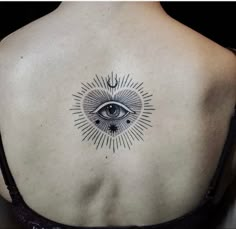 an all seeing eye tattoo on the back of a woman's upper back shoulder