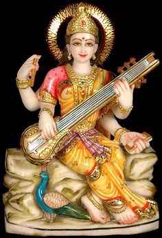 a statue of the hindu god sitting on a rock with a guitar in his hand