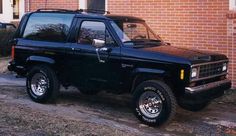 a black truck parked in front of a brick building