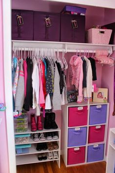 an organized closet with pink and purple bins, white shelves, and lots of clothes