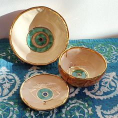 three bowls with an eye on them sitting on a table