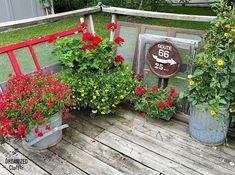 several potted flowers on a wooden deck next to a sign that says route 66