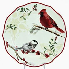 a red and white plate with two birds sitting on it's side, next to a branch