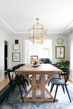 a dining room table with four chairs and a chandelier hanging from the ceiling