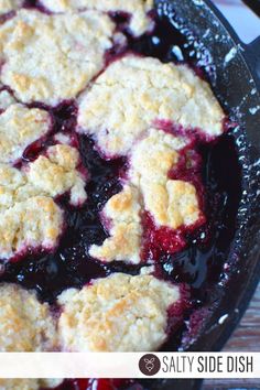 blueberry cobbler in a cast iron skillet with text overlay that reads, salty side dish