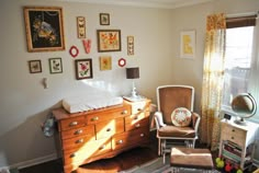 a baby's room with a dresser, chair and crib in the corner