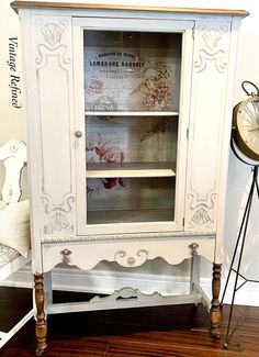 an old china cabinet painted white with floral designs