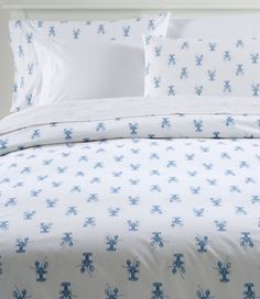 a bed with blue and white flowers on the comforter is shown in this image