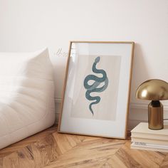 a framed photograph sitting on top of a wooden floor next to a lamp and pillows