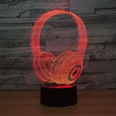 an illuminated headphones on a table next to a brick wall