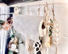 there are many items hanging from the hooks on the wall and in the holder is a roll of rope