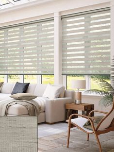 a living room filled with furniture and windows covered in blinds