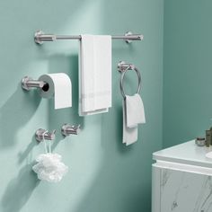 a bathroom with green walls and white towels hanging on the wall next to a sink