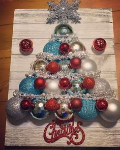 a christmas tree made out of ornaments on top of a wooden board