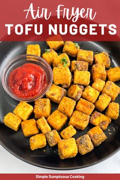 fried tofu nuggets on a black plate with ketchup and sauce