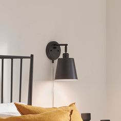 a bed with two lamps on the wall above it