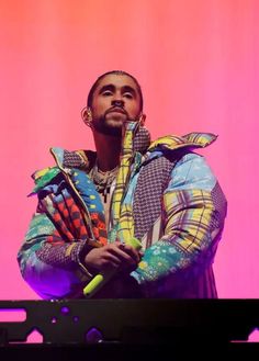 a man standing on top of a stage holding a neon green object in his hand