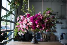 a vase filled with pink flowers sitting on top of a wooden table