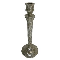 a tall metal candle holder sitting on top of a table