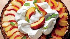 a pie topped with whipped cream and sliced peaches