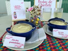 two bowls of pudding on a table with greeting cards and vases filled with flowers