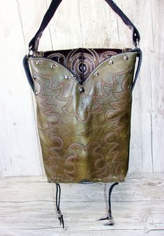 Saddle up and ride in style with the Concealed Carry Cowboy Boot Purse - a handmade, recycled masterpiece that blends western flair with concealed carry convenience. Magnetic closure for quick, discreet access Unique western-inspired accents Interior divider to neatly conceal your protection Roomy 10"x7" design for all your daily essentials Each purse is signed and numbered by the artist Hand-embossed leather strap Make a statement and stay safe with this one-of-a-kind accessory crafted from rec Western Style Brown Bag With Concho, Western Brown Bags For Rodeo, Western Style Bags For Festivals, Western Style Brown Bags For Rodeo, Western Style Travel Bag With Leather Backing, Western Saddle Bag For Everyday Use, Brown Rectangular Bag For Rodeo, Western Style Saddle Bags For Everyday Use, Rectangular Brown Bag For Rodeo