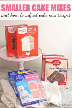 three boxes of cake frosting sitting on top of a white cake stand next to two packages of brownies