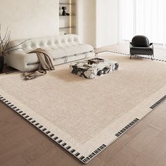 a white couch sitting on top of a wooden floor next to a chair and ottoman