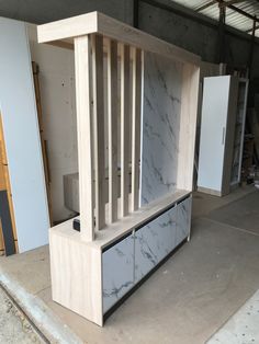 an unfinished cabinet with marble on it in a garage area next to other cabinets and tools