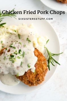 chicken fried pork chops with gravy and mashed potatoes on a white plate