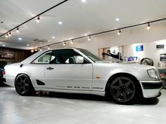 a white car is parked in a showroom