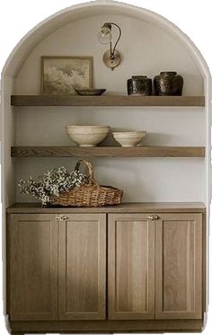 an arch in a wall with shelves and bowls on it