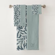 two towels hanging on a towel rack in front of a white wall with black and blue designs