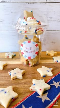 patriotic cookies in a plastic container on top of a wooden table with red, white and blue stars