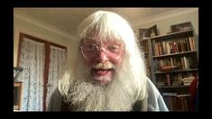 an old man with long white hair and glasses making a funny face in front of a bookshelf