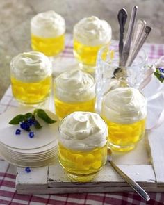 there are many small jars with whipped cream on them and spoons next to each other